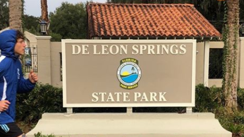 Charles Richardson runs past park sign at De Leon Springs State Park. 
